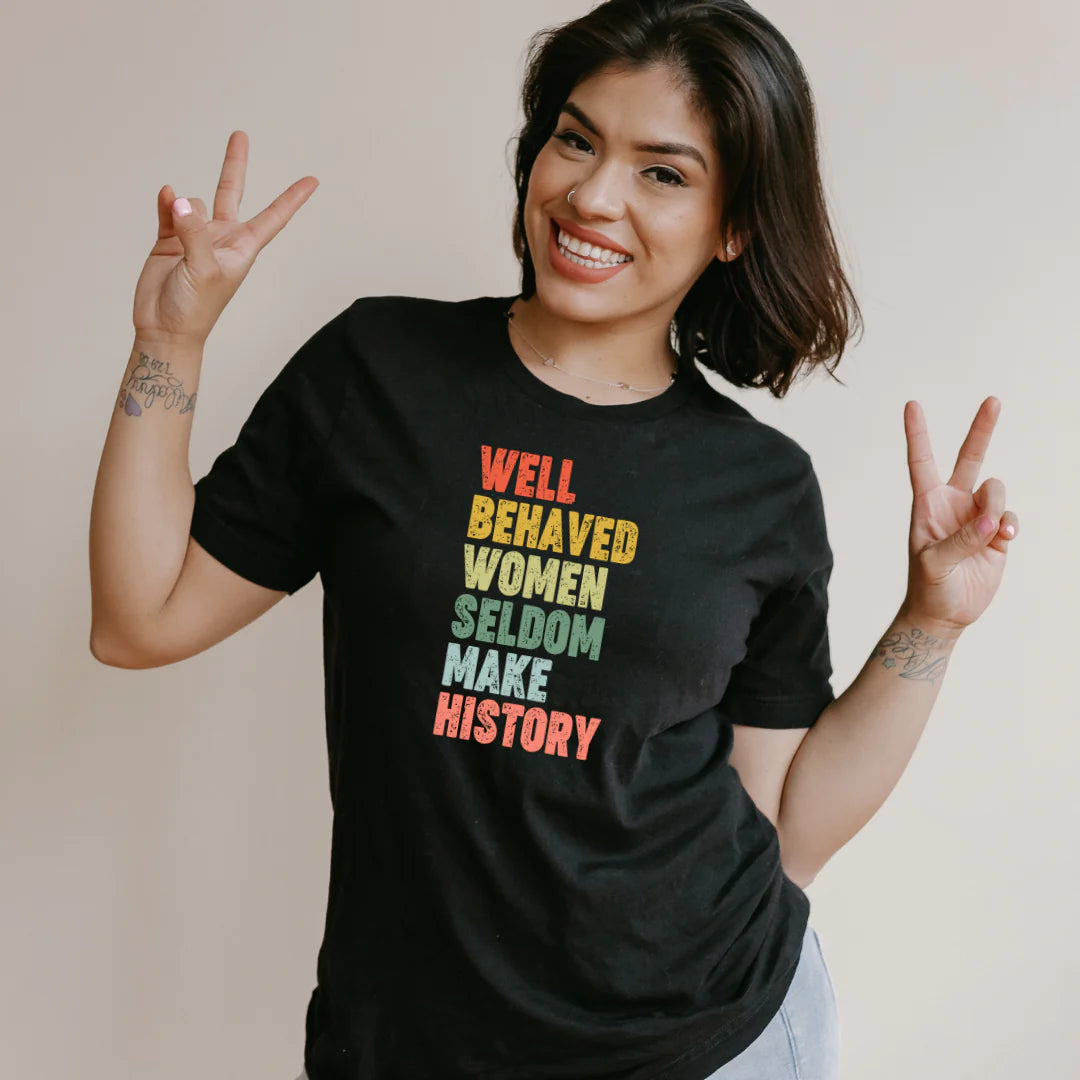 A black cotton t-shirt with a powerful statement that reads, "Well Behaved Women Seldom Make History" This empowering t-shirt celebrates the fight for gender equality, featuring bold typography and a clear message. Perfect for making a statement and sparking conversations, it showcases the importance of equal rights for girls and women in a stylish and impactful way.