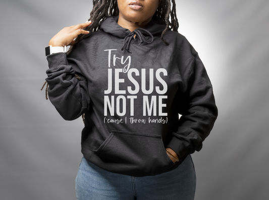 woman wearing a black hoodie that says Try Jesus Not Me (cause I throw hands)